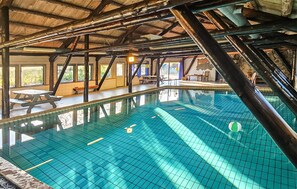 An indoor swimming pool with a tiled floor, wooden beams, and a bench along the side. - Stunning home in Tjørhom with sauna (Tjørhom)
