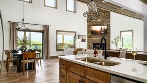 Una cocina amplia con una isla grande, armarios de madera y una pared de acento de piedra.
