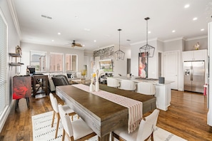 A modern kitchen with a central island, white cabinetry, and a stainless steel refrigerator.