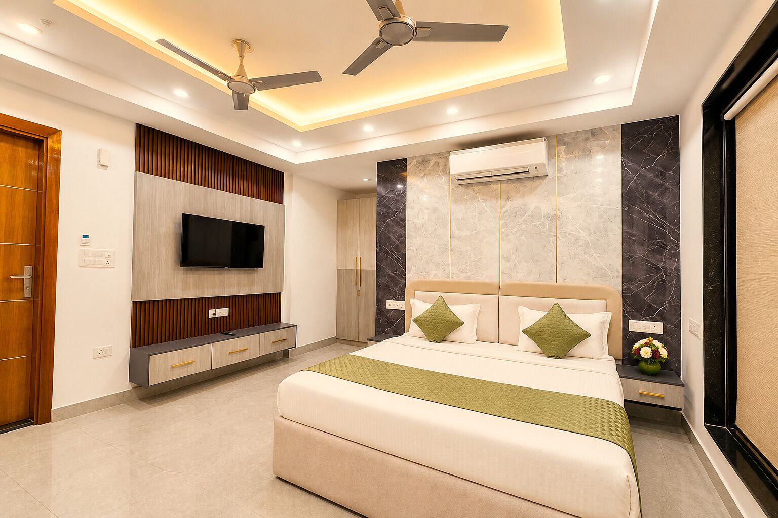 A modern bedroom with a bed, TV, ceiling fan, and marble walls.