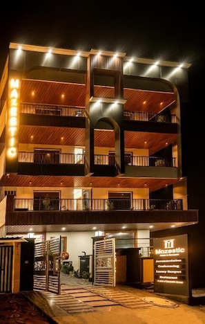 Un hotel de varios pisos con una entrada destacada, balcones e indicación de servicios como spa y restaurante.