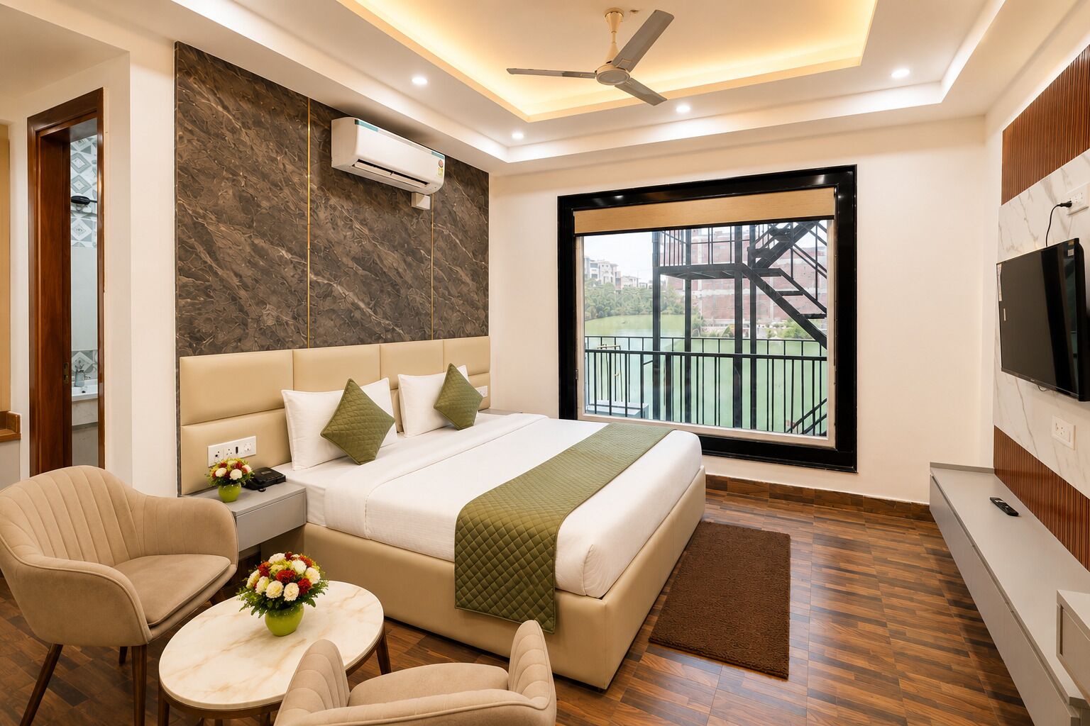 Quarto de hotel moderno com cama, área de estar, televisão e vista para varanda.