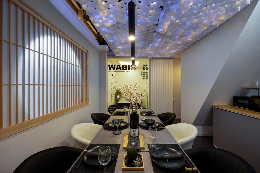 Un comedor moderno con una mesa larga, sillas negras y blancas, y un techo decorativo.