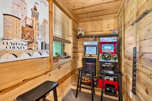 A wooden interior with a map of Cuyahoga County, arcade games, and a bench. - Linden Lodge 7BR Sleeps 16 Hot Tub;Old Mans Cave (Logan)