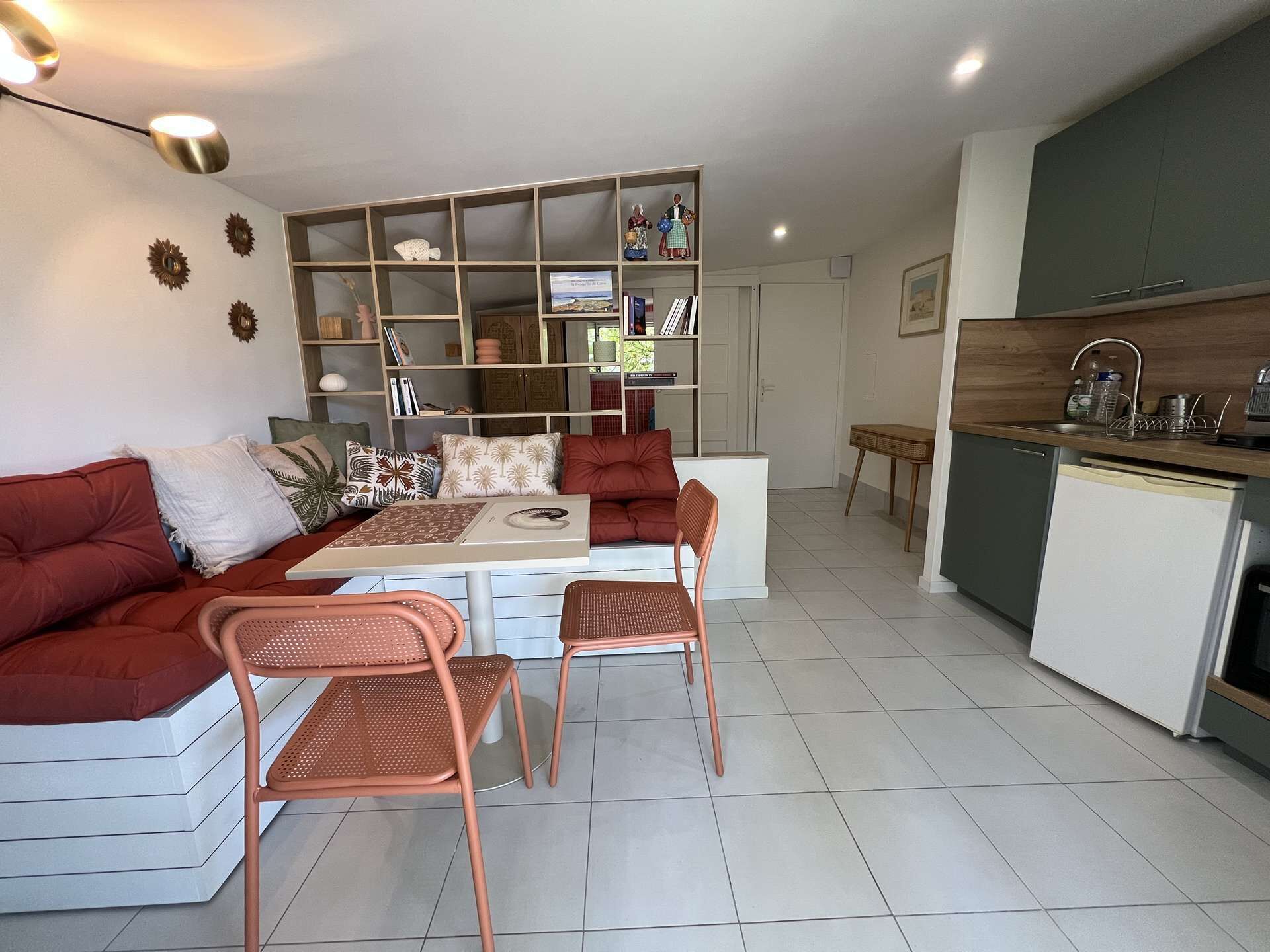 Una sala de estar moderna con un sofá, sillas, una mesa de comedor y una zona de cocina.