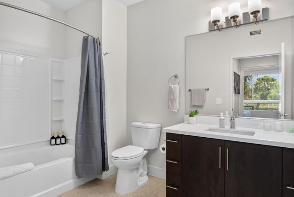 Bright modern bathroom with tub, sleek vanity, and spacious feel