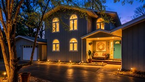 A two-story house with a front porch, a garage, and a driveway.
