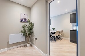 A modern interior with a dining area, a kitchen, and a radiator. - Creative Quarter Luxury 2 Bed City Apt (Birmingham)