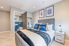 A bedroom with a large bed, a nightstand, and a framed artwork on the wall. - Creative Quarter Luxury 2 Bed City Apt (Birmingham)