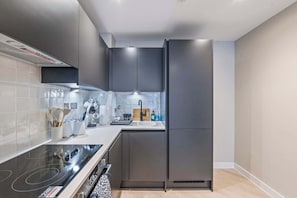 Eine moderne Küche mit Einbauherd, Spüle und Kühlschrank.