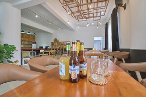A wooden table with bottles and glasses, a bookshelf, and a ceiling with hanging lights. - Zhangjiajie Thirty One  (Zhangjiajie)