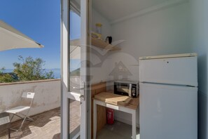 Una cocina pequeña con un refrigerador, un microondas y una mesa de madera.