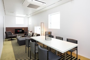 A modern living room with a white table, black chairs, a sofa, and a flat-screen TV. - JAPAVISTA R4 (ROPPONGI, MINATO CITY)