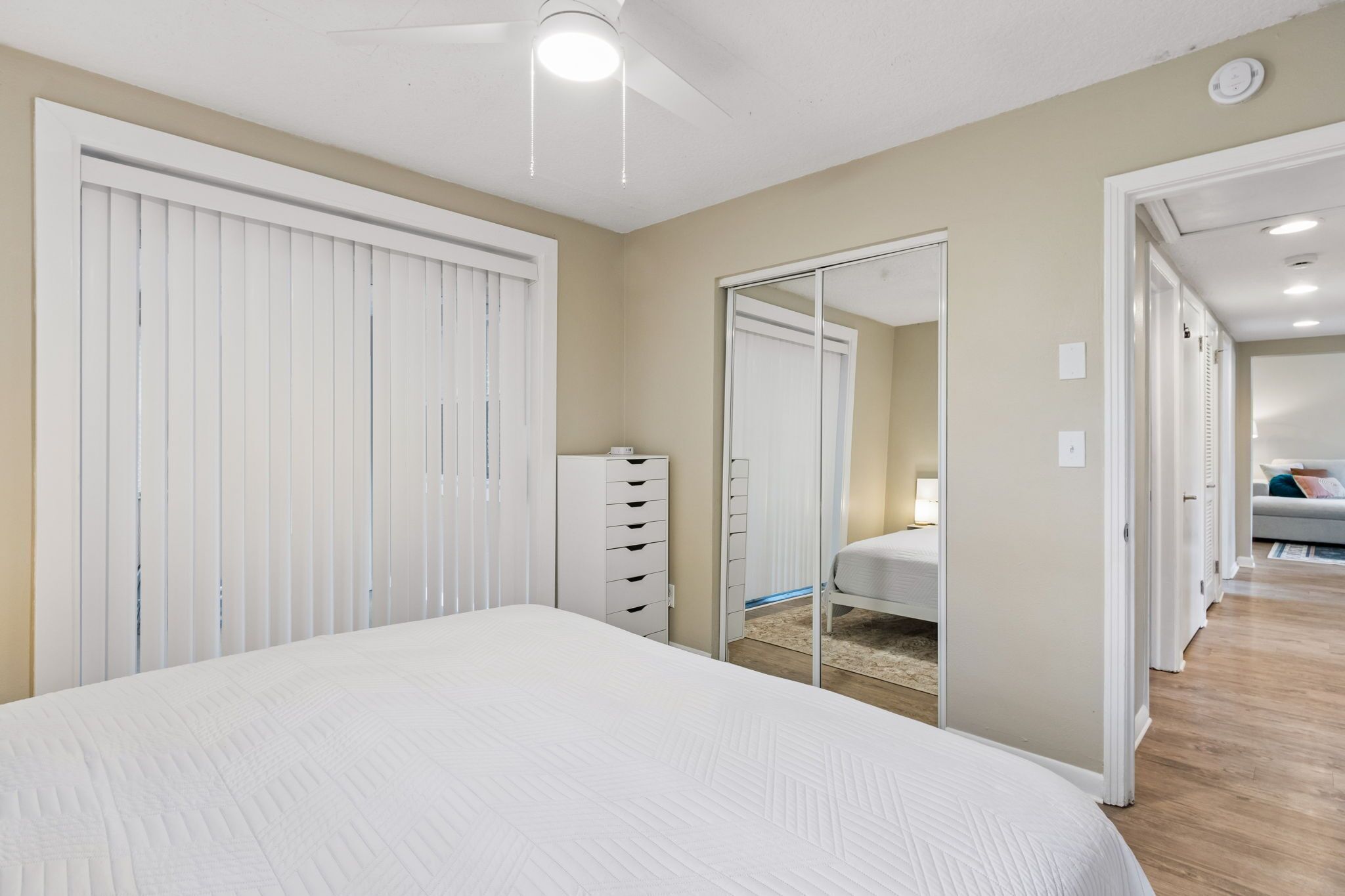 Un dormitorio con cama, armario, cómoda y espejo.