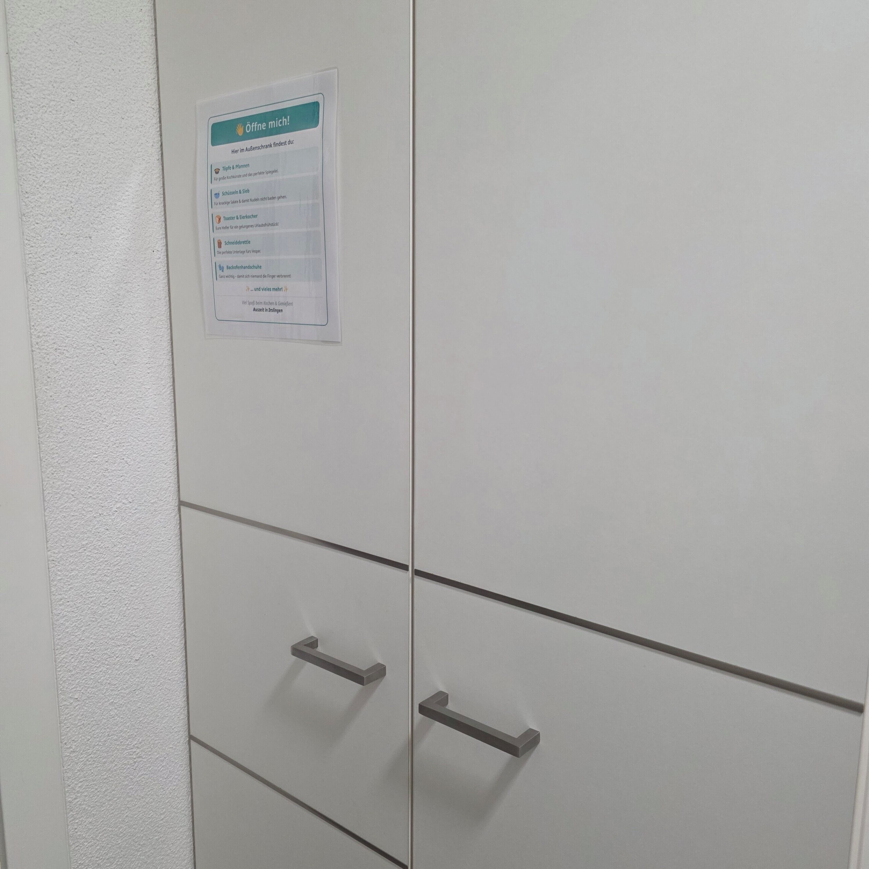 A white cabinet with a sign on it.