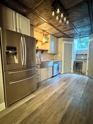 Eine Küche mit einem Edelstahl-Kühlschrank, Holzboden und einem eingebauten Backofen.
