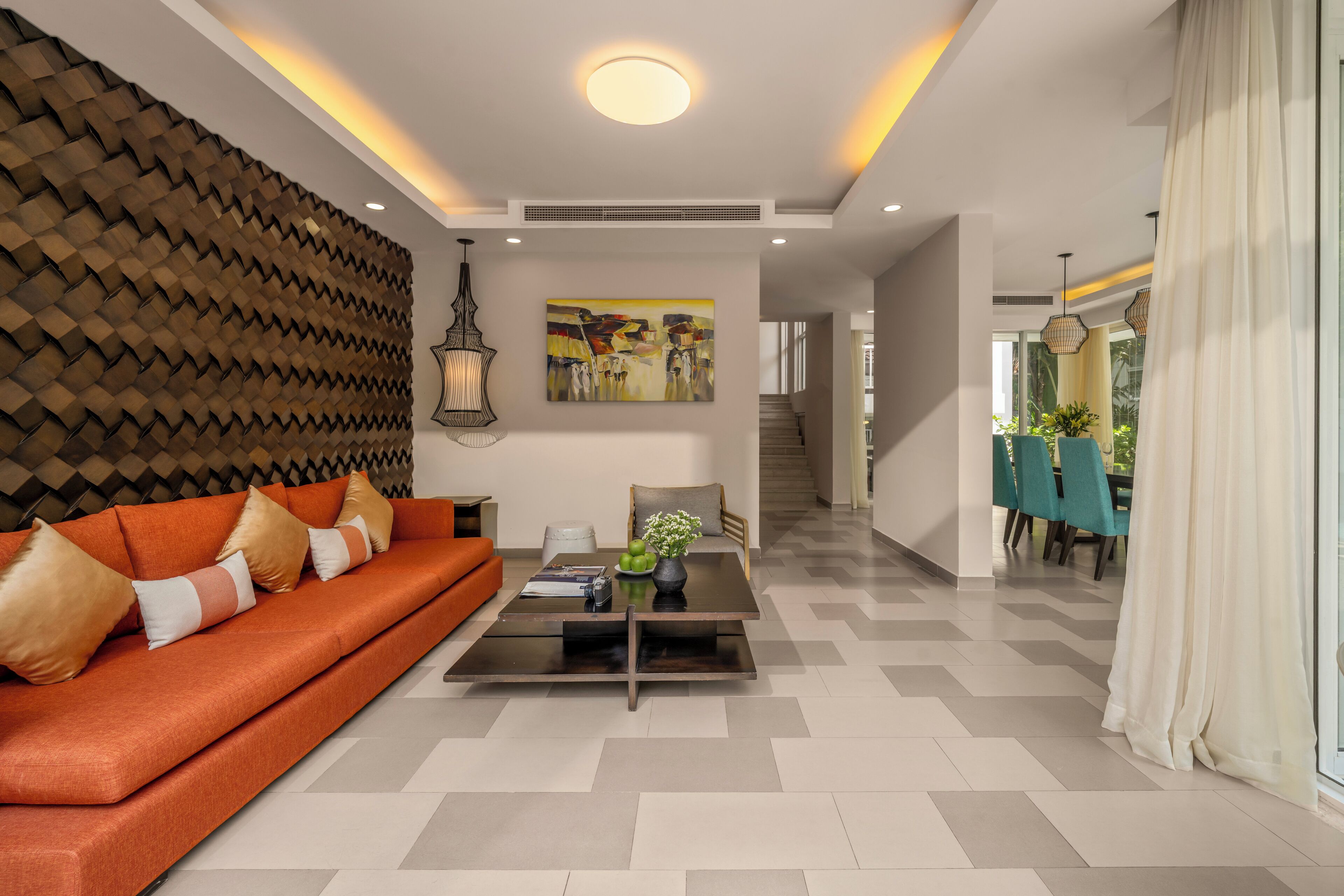 A modern living room with a sofa, coffee table, and artwork.