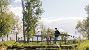 Un ponte sopra un corpo d'acqua calma, con alberi su entrambe le sponde.