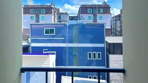 Vista de un complejo de edificios residenciales con varios edificios de apartamentos, cielo azul despejado y algunas nubes.