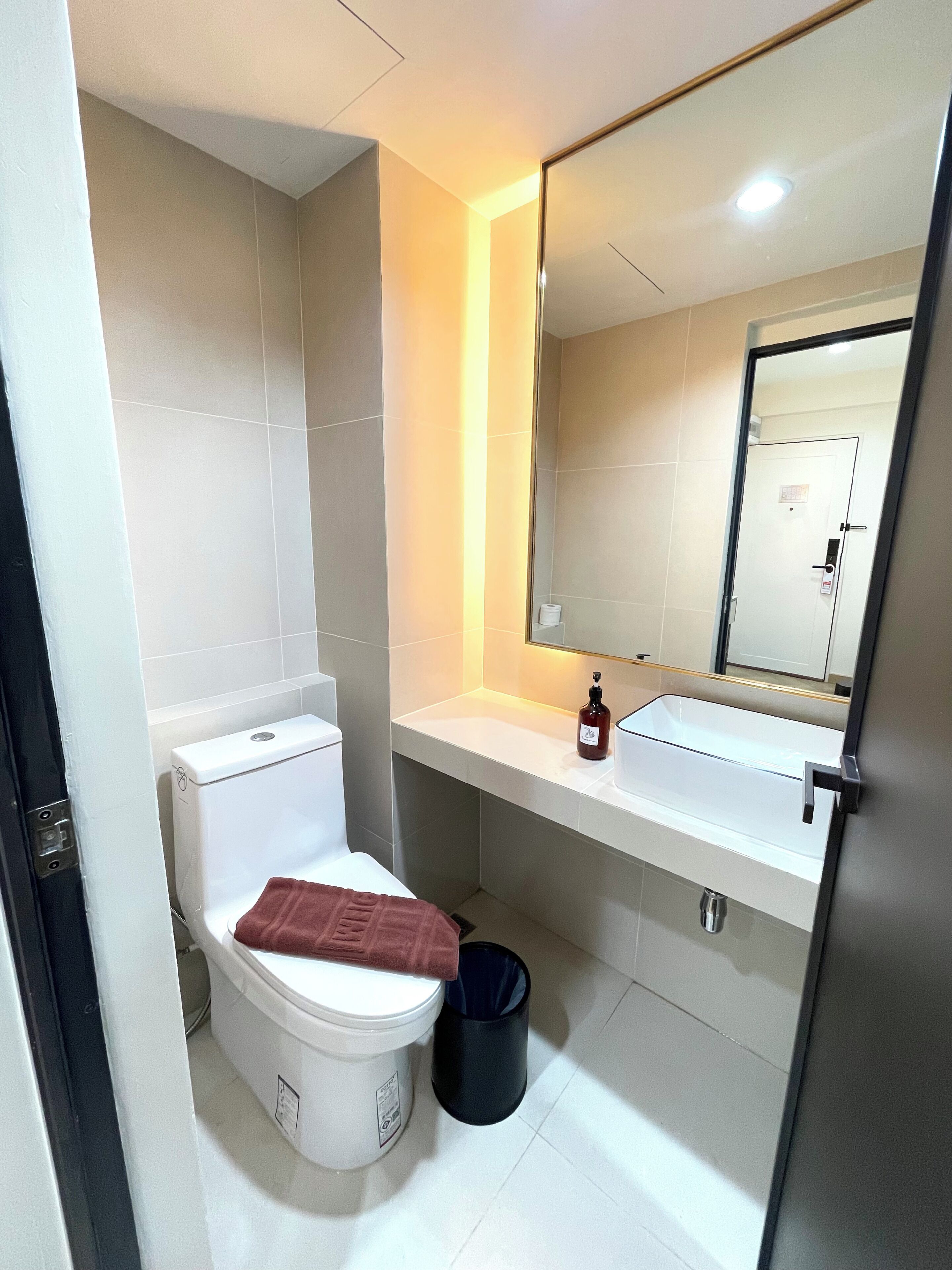 Une petite salle de bain avec des toilettes, un lavabo et un miroir.