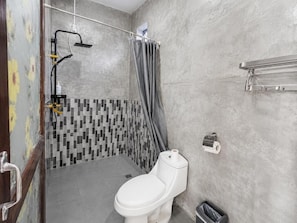 A bathroom with a toilet, shower, and tiled walls.