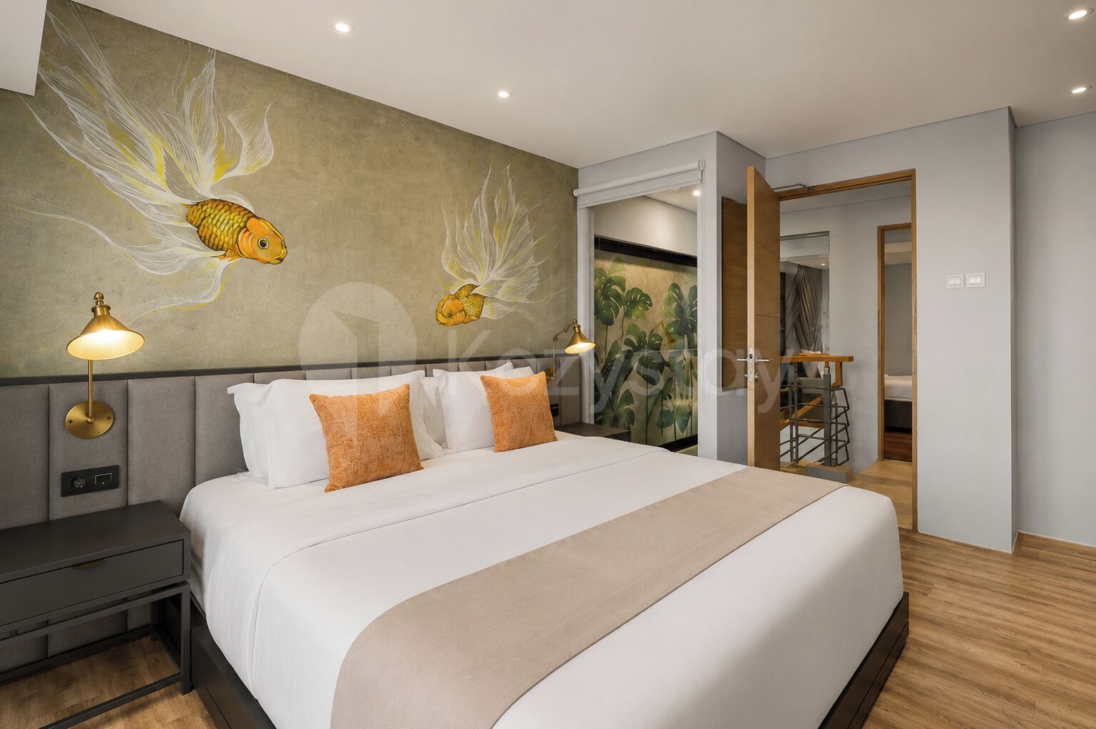 A modern hotel room with a large bed, two bedside lamps, a nightstand, a wall mural, and a view of a staircase.