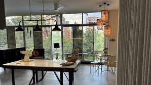 Een moderne keuken met een eethoek, grote ramen en hangende hanglampen.