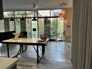A modern kitchen with a dining area, large windows, and hanging pendant lights. - lEPl Cool 2 Bd Duplex in Poblado W/ Good Location (Medellín)