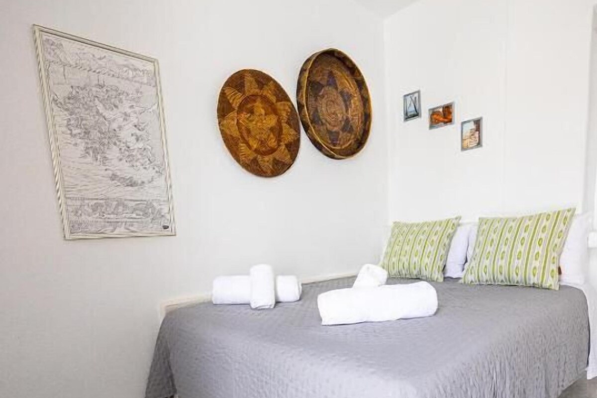 Quarto com cama, travesseiros e cobertor.