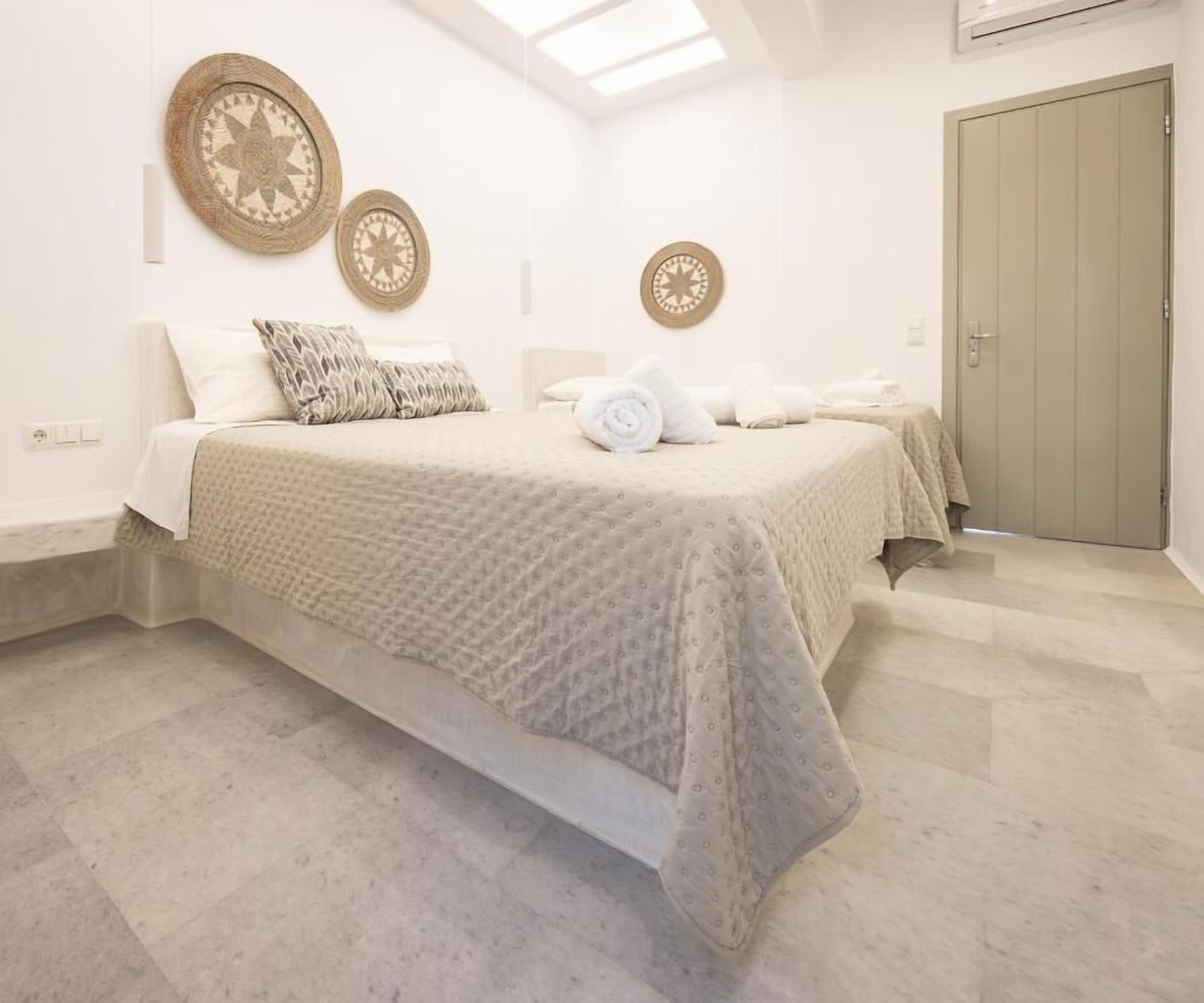 Une chambre à coucher avec un lit, deux éléments de décoration murale, une porte et un interrupteur.