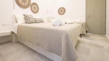 Un dormitorio con una cama, dos adornos de pared, una puerta y un interruptor de luz.