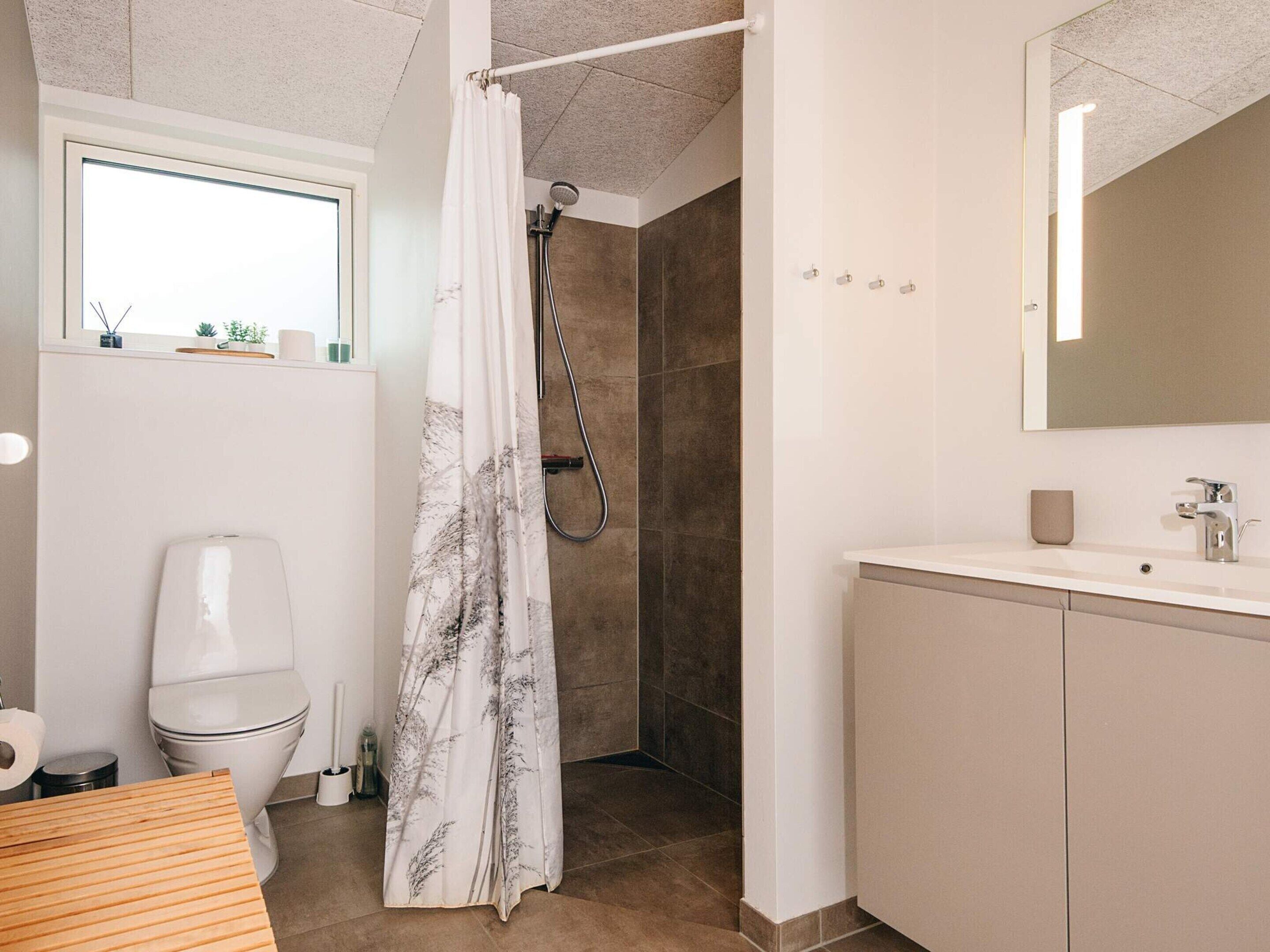 Un baño con ducha, inodoro y lavabo.