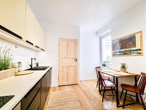 Uma cozinha moderna com armários de madeira, uma pia e um espaço de refeições com cadeiras e uma mesa.