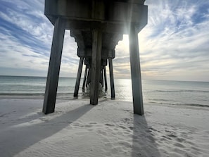 Eine Steg, der sich ins Meer erstreckt, mit blauem Himmel darüber.