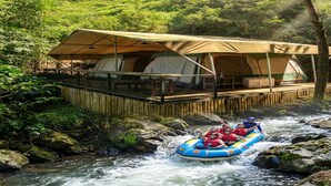 A river rafting activity near a tented accommodation with a view of the river and surrounding greenery. - Cozzy Saprag Riverside Pangalengan (Pangalengan)