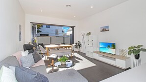 Een moderne woonkamer met een bank, een eettafel en een televisie.