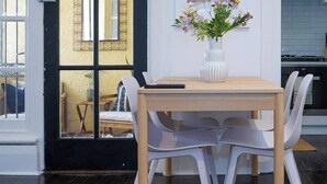 En matplats med ett träbord, vita stolar och en vas med blommor.
