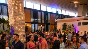 Un événement social se déroulant dans un grand espace intérieur, doté d’un sol carrelé et de murs en briques.