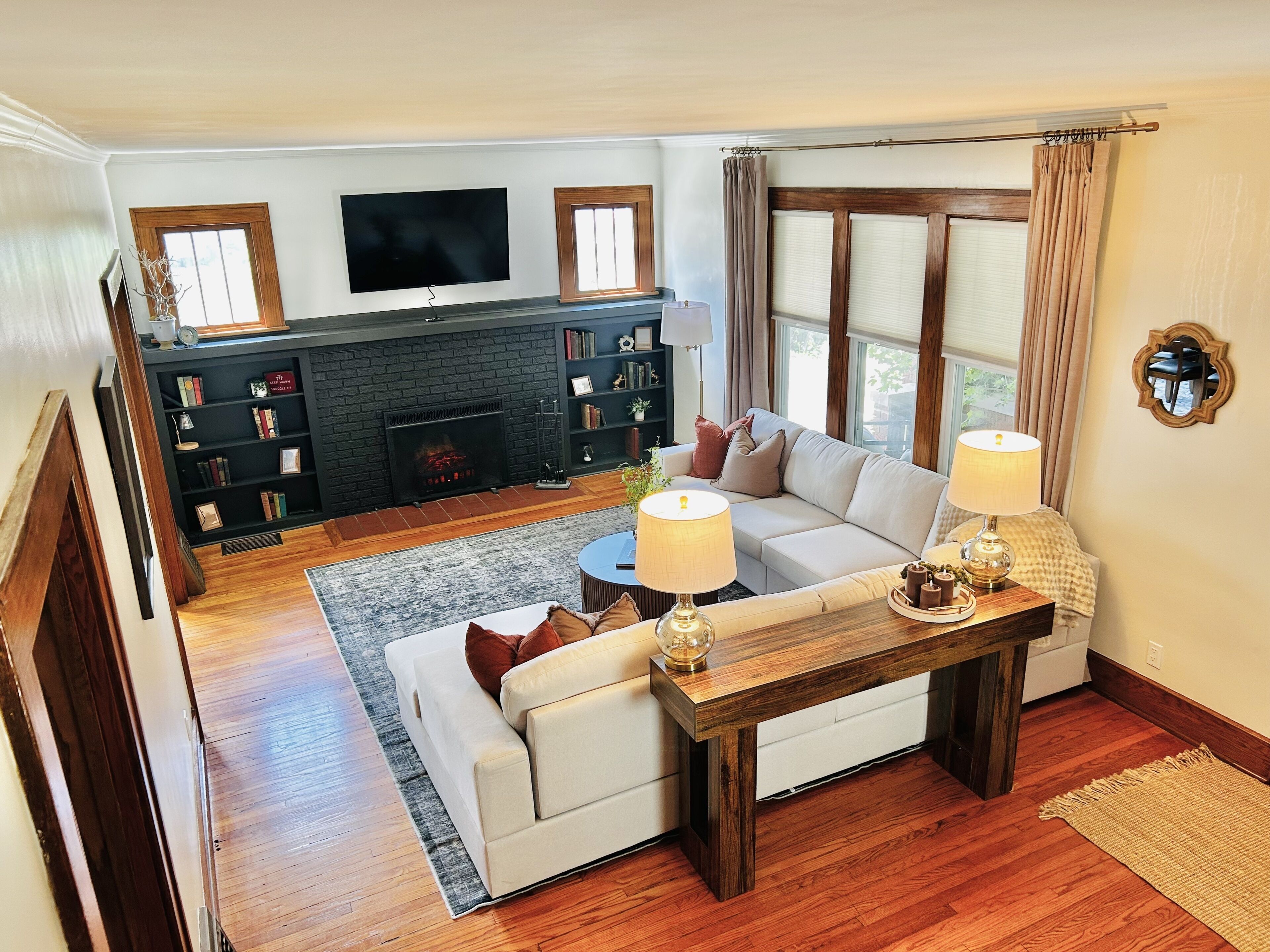Cozy living room with sectional, fireplace, built-ins, and bright windows