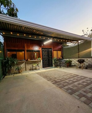 A modern building with a covered patio, outdoor seating, and potted plants. - 2BR Home Near Ocotal Beach | 5 Min to the Beach, 8 Min to Coco (Coco)