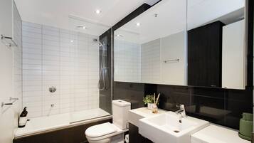 A modern bathroom with a bathtub, toilet, and sink.