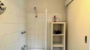 Ein Badezimmer mit Badewanne, Dusche und Ablage für Toilettenartikel.
