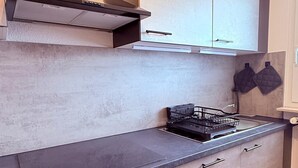 Uma cozinha moderna com fogão a gás, forno e bancadas de aço inoxidável.