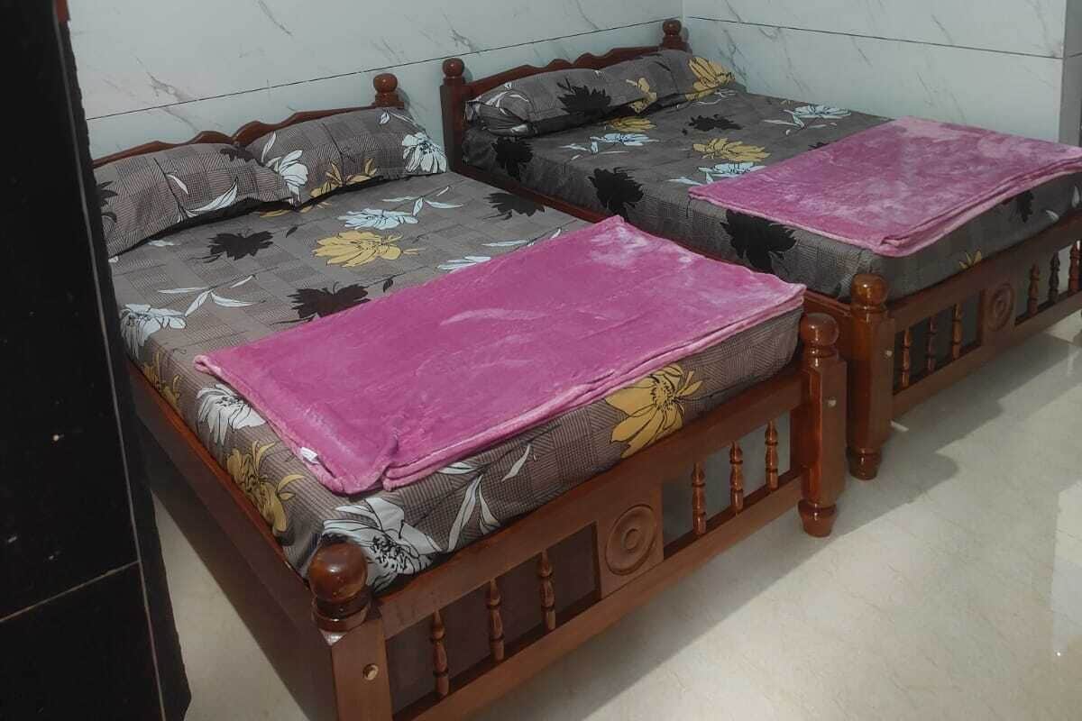 A room with two wooden beds, a ceiling fan, and an air conditioning unit.