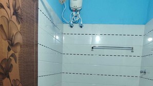 Un baño con inodoro, ducha y secador de manos.