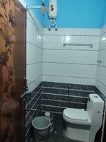 Un baño con inodoro, ducha y secador de manos.