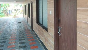 Un pasillo con suelo estampado, paredes de madera y puertas con ventanas.