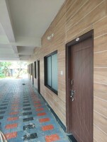 Un pasillo con suelo estampado, paredes de madera y puertas con ventanas.