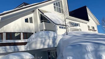 A modern two-story house with a garage, covered in snow.