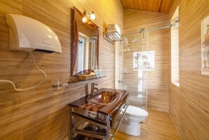 A modern bathroom with a wooden vanity, a mirror, a towel rack, and a shower area. - MAC VALLEY DALAT HOTEL (Xuan Huong - Da Lat)
